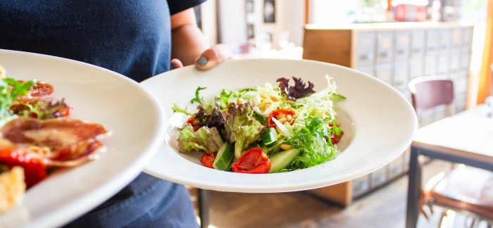 Kellnerin Serviert Teller mit Salat